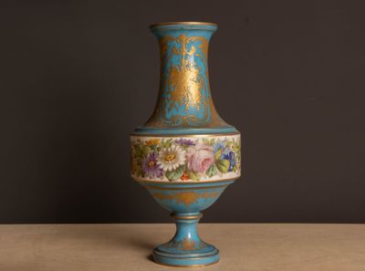 a blue vase sitting on a table with a black background