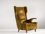 un fauteuil à oreilles en velours vert, avec une structure et des accoudoirs en bois
