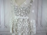 a white dress with flowers on it on a mannequin