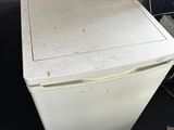 a white refrigerator sitting on the floor in a room