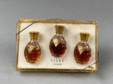 trois flacons de parfum posés dans une boîte sur une table