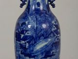 un vase bleu et blanc posé sur une table en bois