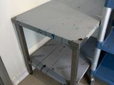 a metal table with a blue chair next to it