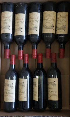 Plusieurs bouteilles de vin sont posées dans une boîte en carton sur une table
