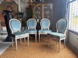 four blue chairs in a room with a window and a rug