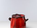 un gros plan d'un pot rouge posé sur une table