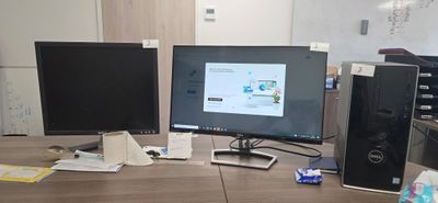 three computer monitors on a desk with a keyboard and mouse
