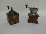 two old coffee grinders on a white surface