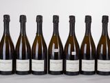 six bottles of wine are lined up in a row on a table