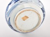 a blue and white vase on a white surface