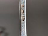 a silver spoon with a silver handle on a table