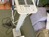 une machine blanche posée sur un lit, à côté d'un oreiller