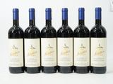 six bouteilles de vin sont alignées sur une surface blanche