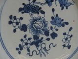 a blue and white plate with a flower design on it