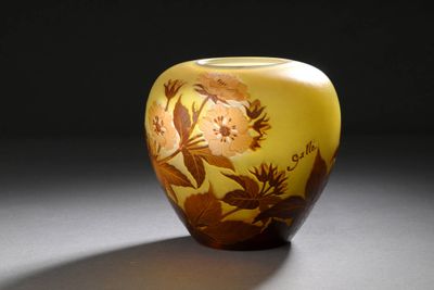 un vase jaune orné d'un motif floral posé sur une table