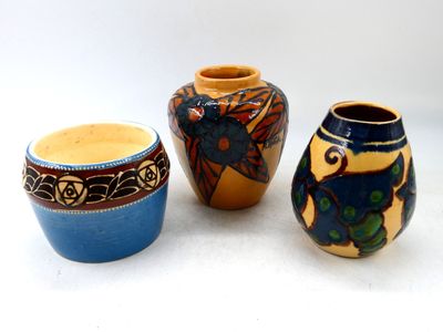trois vases posés l'un à côté de l'autre sur une surface blanche