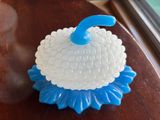 a blue and white cupcake on a table next to a window