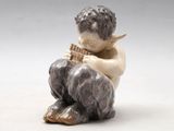 une petite figurine représentant un garçon jouant de la flûte