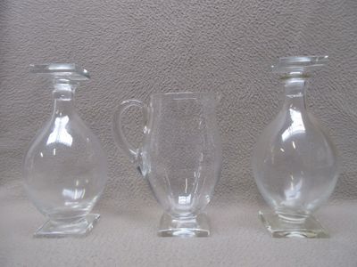 trois vases en verre posés l'un à côté de l'autre sur une table
