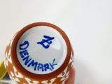 une personne tenant une tasse décorée de motifs bleus et blancs