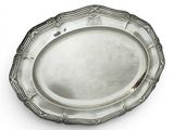 une assiette en argent antique avec un motif décoratif sur le bord