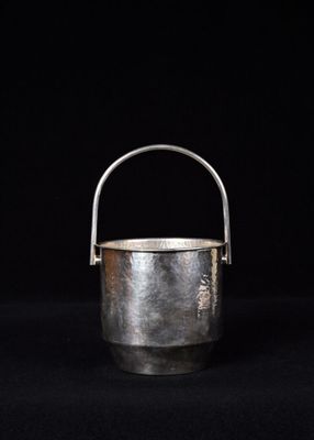 un vieux seau en argent sur fond noir