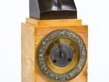 un buste d'homme assis au sommet d'une horloge