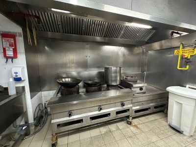 une grande cuisine en inox équipée d'une cuisinière et d'un évier