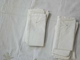 two pairs of white gloves sitting on a white sheet