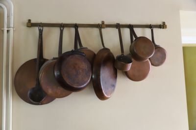 de nombreuses casseroles et poêles accrochées au mur