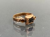 a close up of a gold ring with a black stone in it