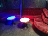 un canapé et une table dans une pièce éclairée par des lumières rouges et bleues