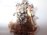 a picture of a broochle with a bunch of flowers on it