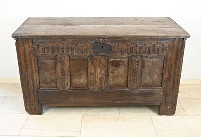 a wooden chest sitting on a tile floor in a room