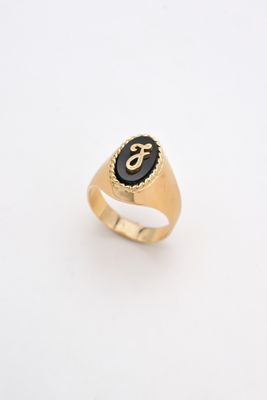 a gold signet ring with a black stone in the center