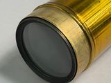 a close up of a telescope lens on a white surface