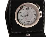 a black clock with a white face on a black leather case