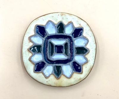 une petite assiette bleue et blanche ornée d'un motif floral