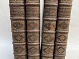 un ensemble de cinq livres anciens reliés en cuir sur fond blanc