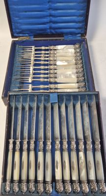 un service d'argenterie dans un coffret bleu posé sur une table