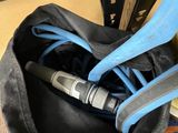 a black bag with a blue handle and a pair of scissors in it