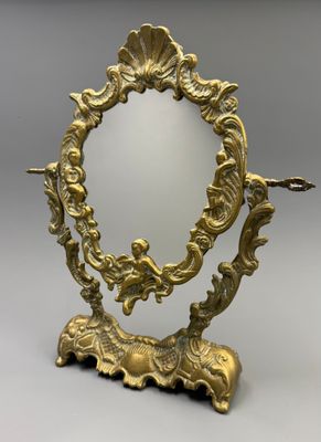 une image représentant un miroir à cadre doré posé sur un socle