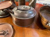 many pots and pans sitting on a wooden table