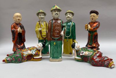 cinq figurines représentant des hommes asiatiques et un chien