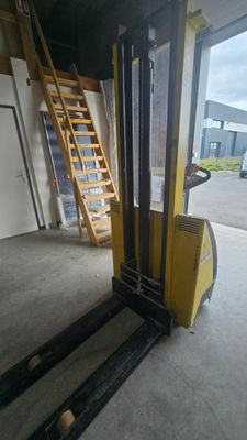 a forklift in a warehouse with a ladder