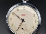 a close up of a pocket watch on a table