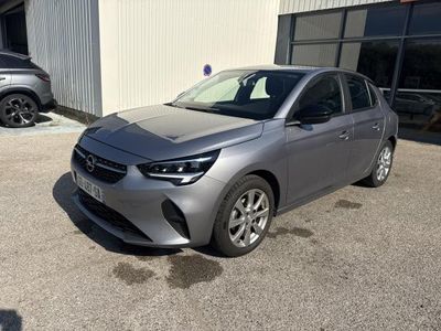 une voiture grise garée devant un immeuble, à côté d'autres voitures