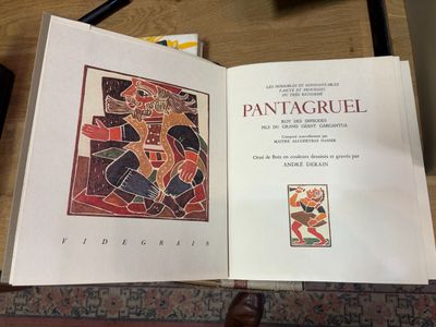 un livre ouvert sur lequel figure l'image d'un homme, posé sur une table