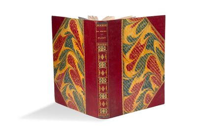 un vieux livre à la couverture rouge, orné d'un motif jaune et rouge
