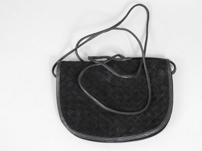 sac à main en cuir noir sur fond blanc, avec une bandoulière noire